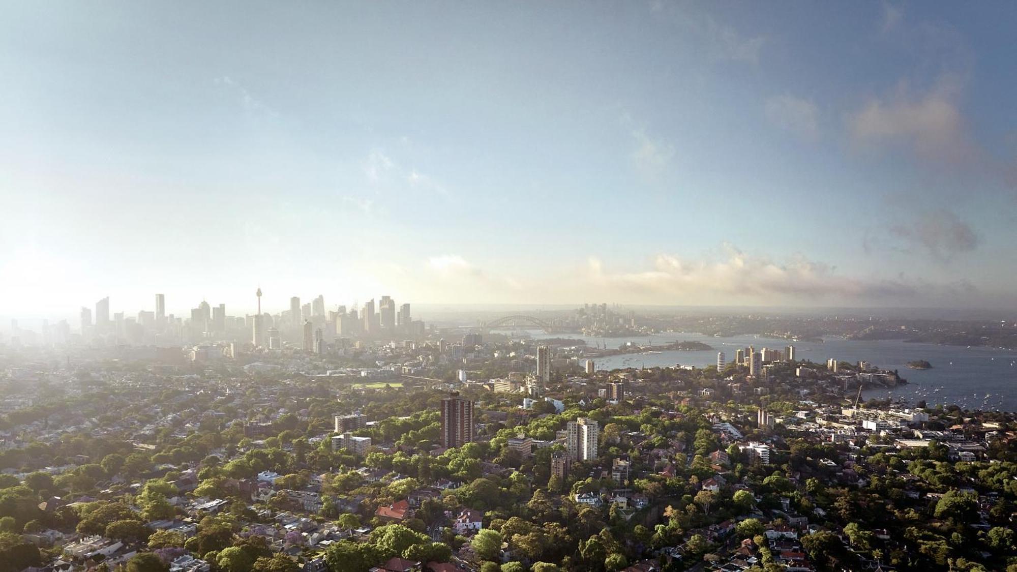 Meriton Suites Bondi Junction Сидней Экстерьер фото The photo shows a panoramic view of a city skyline, likely taken from a high vantage point. In the foreground, there are lush green trees and buildings, suggesting a suburban area. As the view extends towards the background, tall skyscrapers dominate